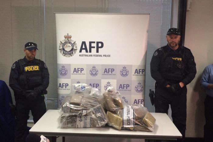 Police with some of the drugs seized in the largest bust of cocaine in the Queensland's history