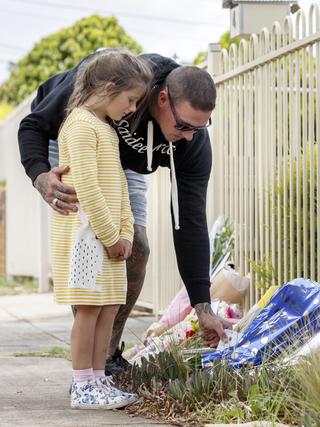 Mark Stephens and daughter Sienna lay a tribute at the Perinovics house in Tullamarine on Friday. Picture: David Geraghty