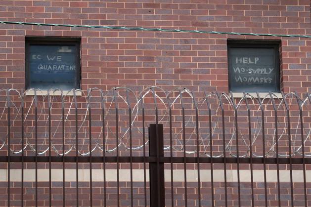Signs pleading for help hang in windows at the Cook County jail complex on April 09, 2020 in Chicago, Illinois.