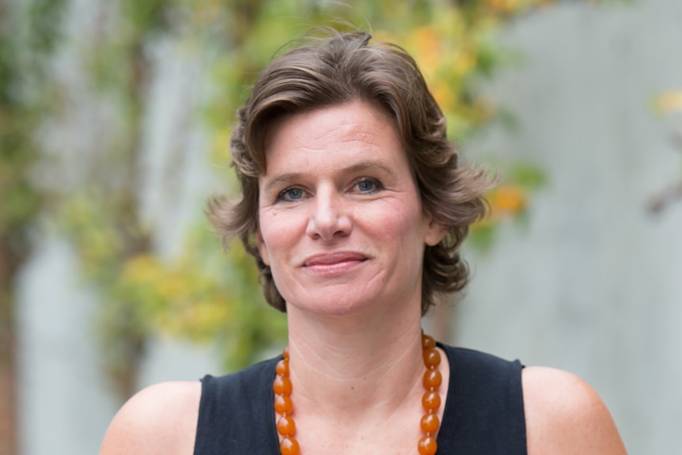 Close up of Mariana Mazzucato's face. Smiling at camera. Wearing amber necklace looking professional.