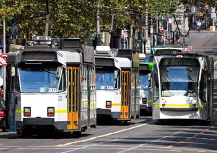 Trams moving along Melbourne CBDs busy main thoroughfare, Swanston Street.